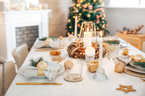 Beautiful table setting with Christmas decorations in living room photo