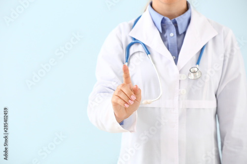 Doctor using virtual screen on color background