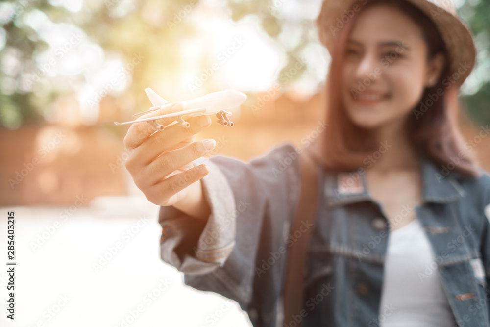 Smiling woman traveler in thapae gate landmark chiang mai thailand with backpack holding airplane model on holiday, relaxation concept, travel concept Smiling woman traveler in thapae gate landmark chiang mai thailand with backpack holding airplane model on holiday, relaxation concept, travel concept