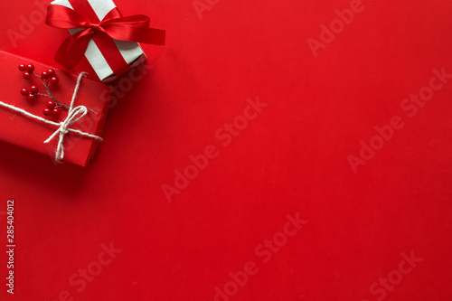 Christmas gifts presents on red background. Simple, classic red and white wrapped gift boxes with ribbon bows and festive holiday decorations