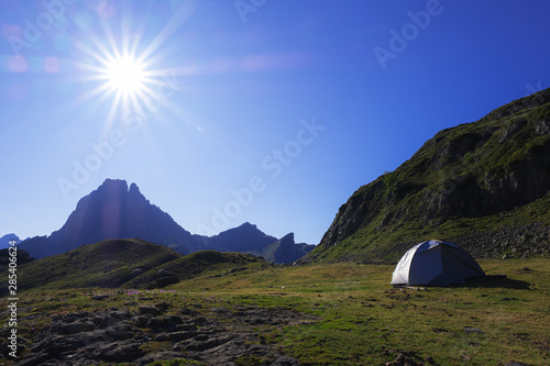 camping tent with the midi d'Ossau and the sun in the background in the Pyrenees National Park, France