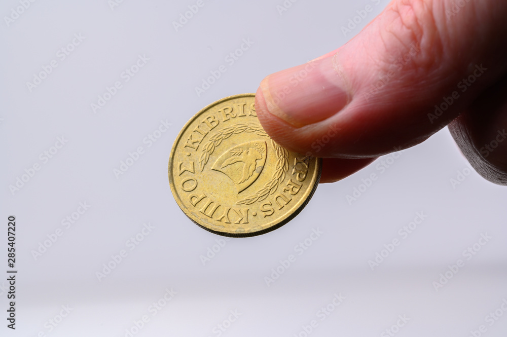 Cyprus twenty coin crown side in human hand for payment on white background with copy space Cyprus twenty coin crown side in human hand for payment on white background with copy space