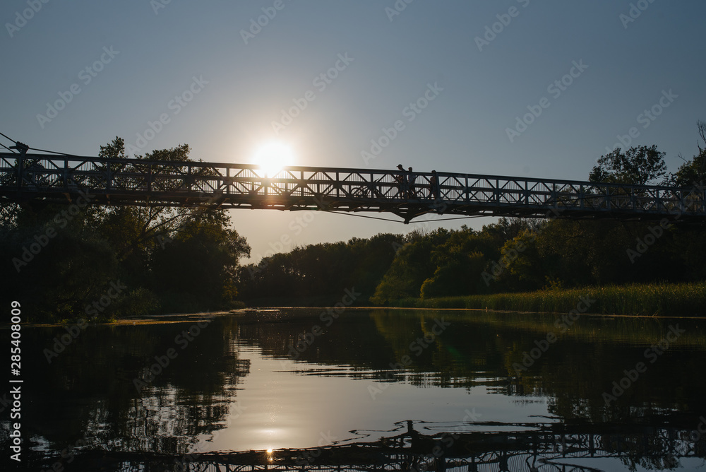 Fototapeta premium Bridge on river in sunset lights.