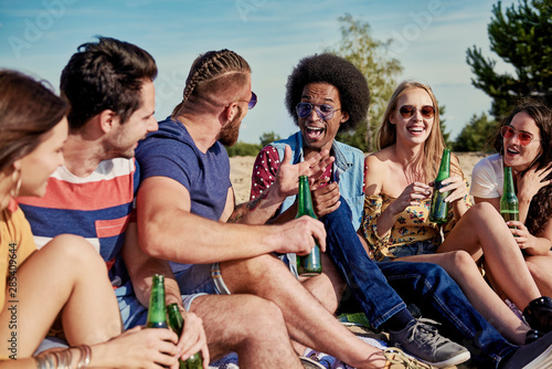 Six young people drinking beer outside © gpointstudio