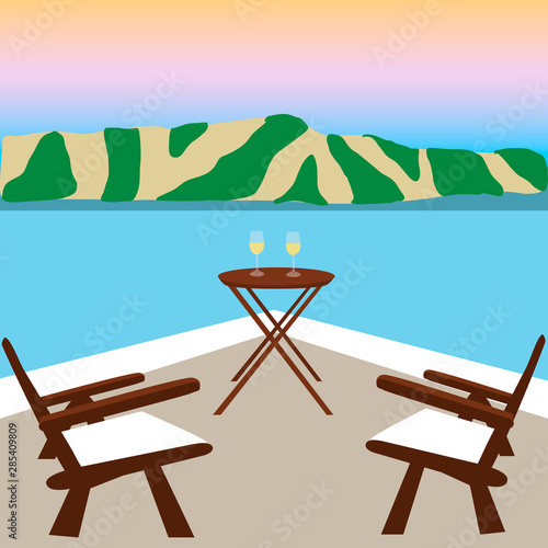 Two wooden chairs on balcony with view on seafront
