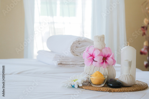 Spa treatment set and aromatic massage oil on bed massage. Thai setting for aroma therapy and massage with flower on the bed, relax and healthy care.