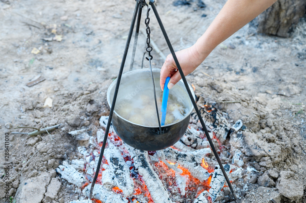 potatoes are cooked in a pot over the fire potatoes are cooked in a pot over the fire
