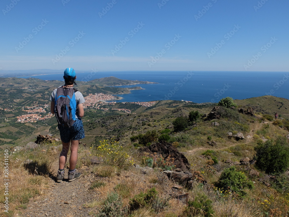 jeune garçon en randonnée sur les hauteurs de la mer vers banyuls avec ciel bleu