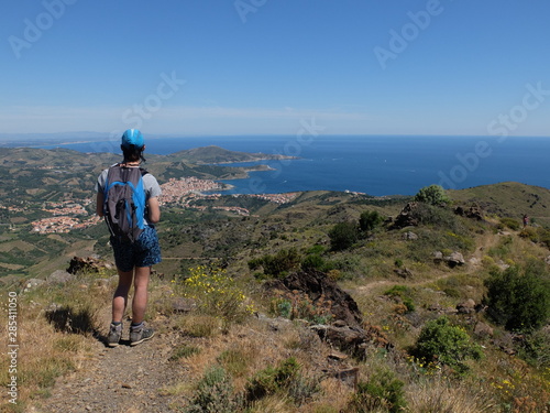 jeune garçon en randonnée sur les hauteurs de la mer vers banyuls avec ciel bleu © Ourson+