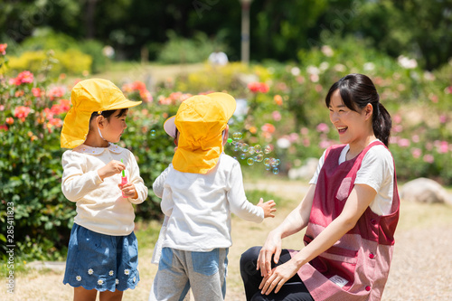 公園で遊ぶ保育士と園児たち photo