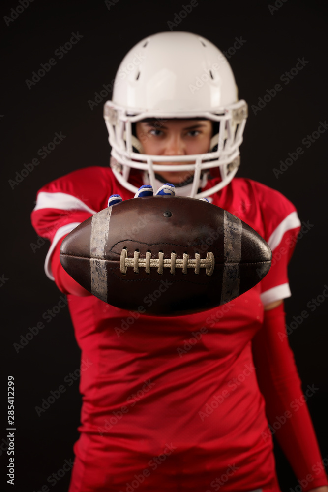 Picture of american woman football player in helmet with arm outstretched forward