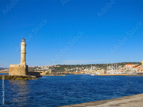 Photo of iconic old Venetian lighthouse in old harbour of Chania. Crete island, Greece