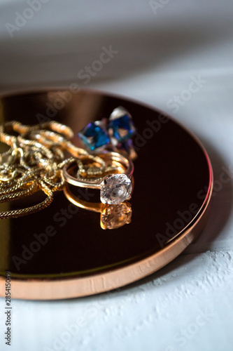 Golden ring with diamonds. Female jewelry on a table, close up.