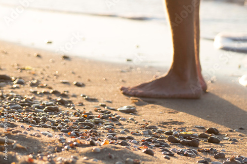 Men's legs are on the beach