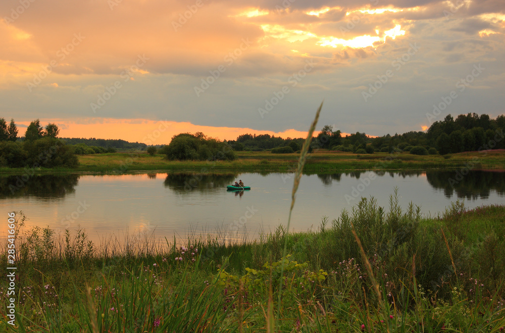 Evening fishing on the Zapadnaya Dvina river, summer sunset after rain.