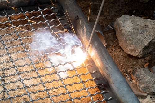 worker used electric welding wire mesh to make bird cage. photo