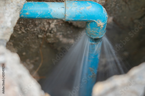 leaking water from blue pipe from underground