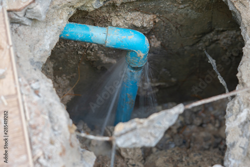 Fotobehang leaking water from blue pipe from underground