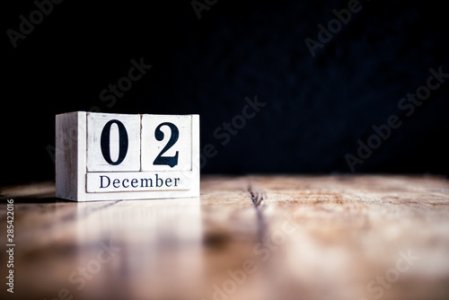 December 2nd, 2 December, Second of December - White block calendar on vintage table - Date on dark background photo