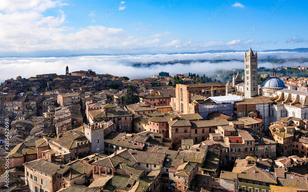 Siena, Tuscany, view from the top of the Torre del Mangia with roofs, countryside and fog