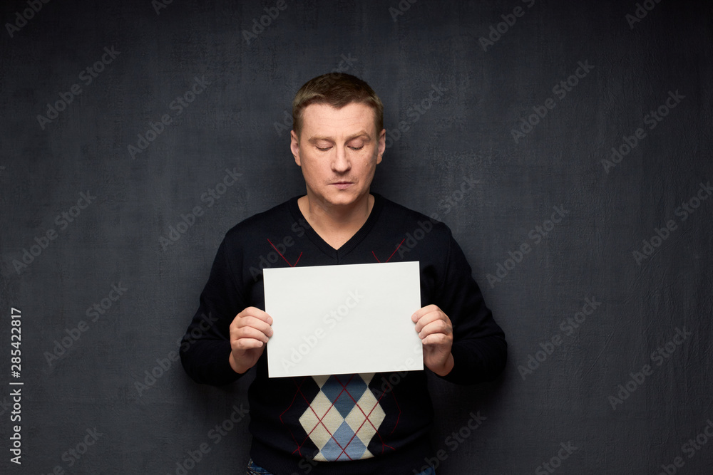 Naklejka premium Portrait of man holding white blank paper sheet
