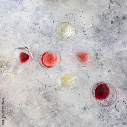 Flat-lay of red, rose , white  and bordeaux wine in glasses over grey concrete background. Wine degustation concept