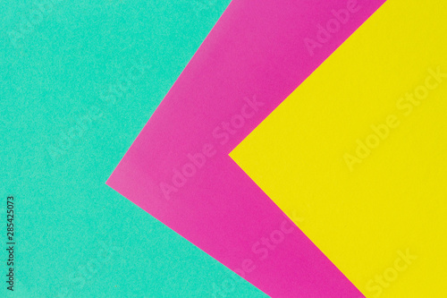 Abstract geometric paper background. Neon gradient of mint, purple, and yellow trendy colors. Geometric vibrant colors textured flat lay.