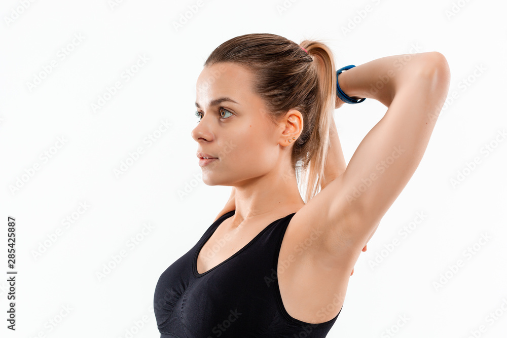 Young sporty blond woman in a black sportswear stretching before exercising isolated over white background. Young sporty blond woman in a black sportswear stretching before exercising isolated over white background.