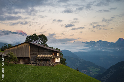 Chalet in the Alps at sunset with alpenglow on top of the mountains