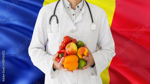 Andorran Doctor is holding fruits and vegetables in hands with Andorra flag background. National healthcare concept, medical theme.