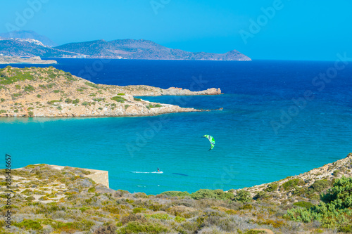 Achivadolimni sandy beach in Milos greek island in beach. A kite surfer rides the waves in the sea