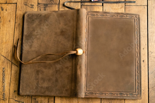 Old leather bound book with bookmark and a blank cover, on a wooden table