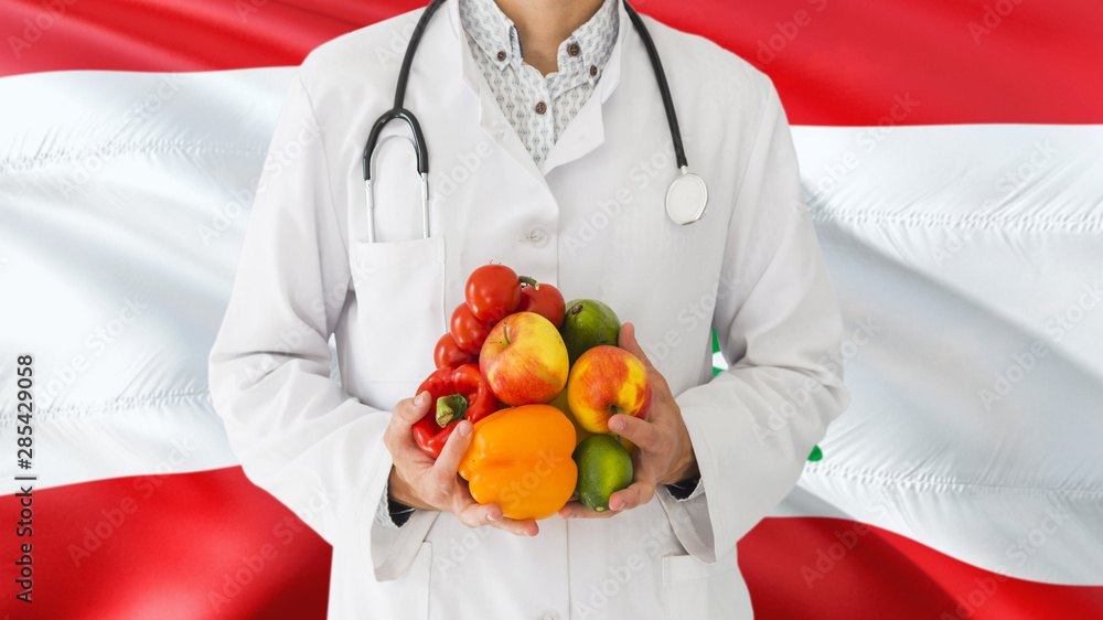 Doctor is holding fruits and vegetables in hands with Lebanon flag background. National healthcare concept, medical theme. Doctor is holding fruits and vegetables in hands with Lebanon flag background. National healthcare concept, medical theme.