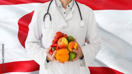 Doctor is holding fruits and vegetables in hands with Northern Cyprus flag background. National healthcare concept, medical theme.