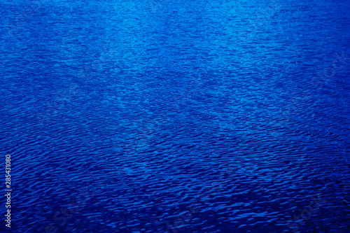 Shining dark blue wavy water surface ripple background