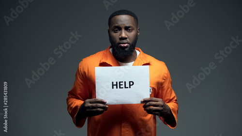 African-american male prisoner holding help sign, asking for justice, abuse photo