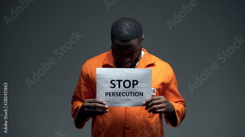 Afro-american prisoner holding stop persecution sign, racial discrimination