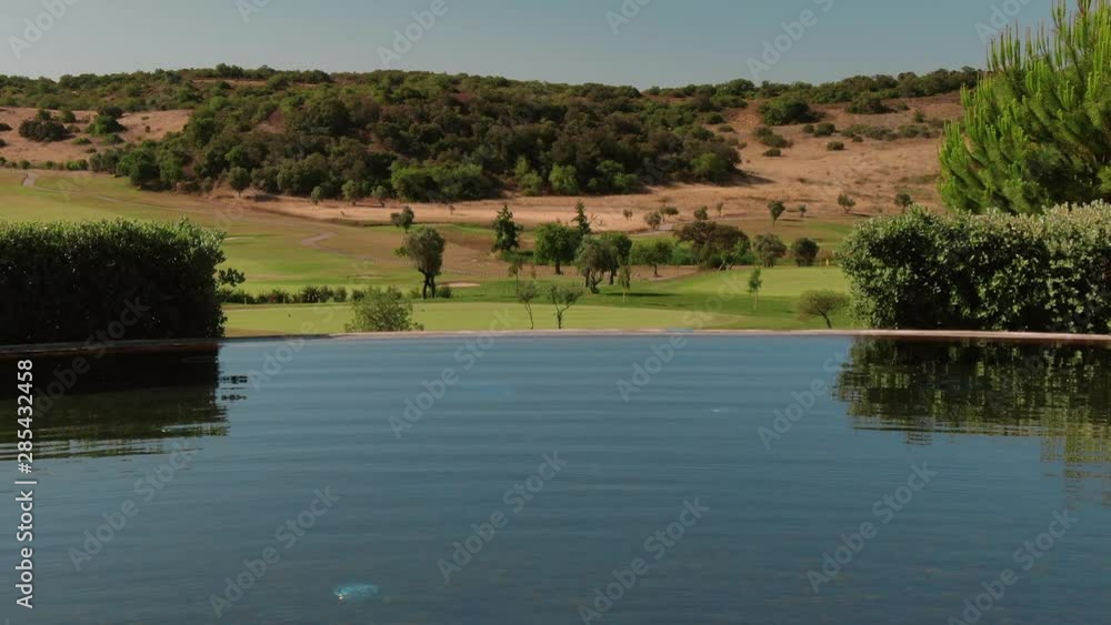 Aerial view above infinity pool luxury resort surrounded by nature Aerial view above infinity pool luxury resort surrounded by nature
