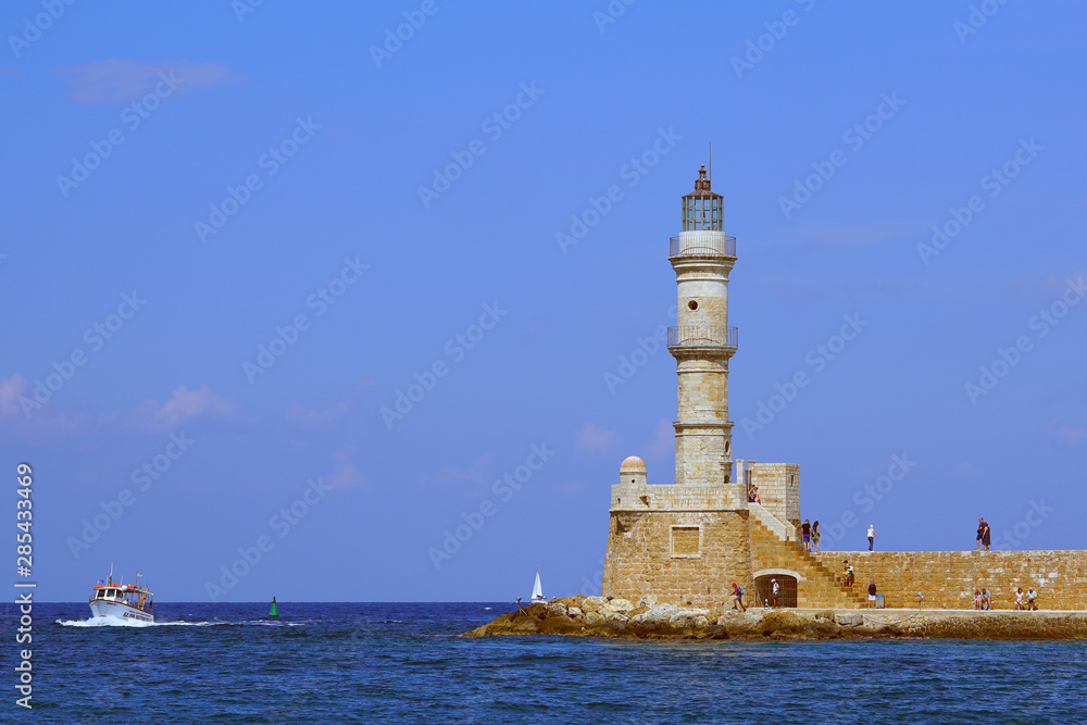 View of the lighthouse and a boat in the port of Chania