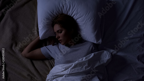 Beautiful female snoring in bed, serious health problems, sleep apnea risk