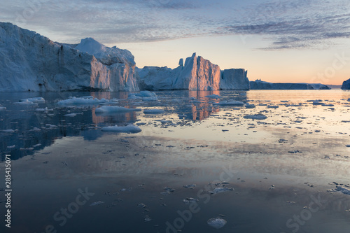 Nature and landscapes of Greenland or Antarctica. Travel on the ship among ices. Studying of a phenomenon of global warming Ices and icebergs of unusual forms and colors Beautiful midnight sun on ship