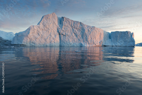 Nature and landscapes of Greenland or Antarctica. Travel on the ship among ices. Studying of a phenomenon of global warming Ices and icebergs of unusual forms and colors Beautiful midnight sun on ship