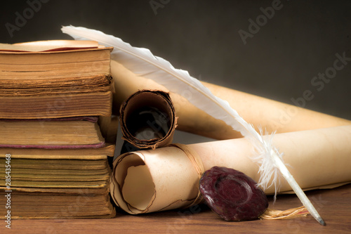 Papyrus scrolls on a table top with books and pen
