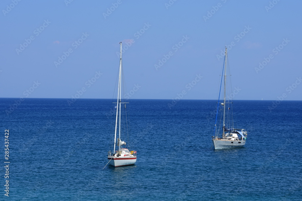 A view of the beautiful blue waters of the Mediterranean Sea and the yachts of the Greek island of Rhodes. A view of the beautiful blue waters of the Mediterranean Sea and the yachts of the Greek island of Rhodes.