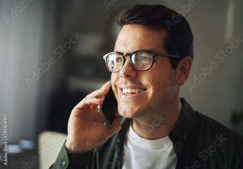 Close-up of a cheerful man talking on mobile phone