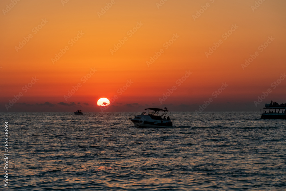 Beautiful Golden sunset on the sea. In the sea at sunset sail boats.