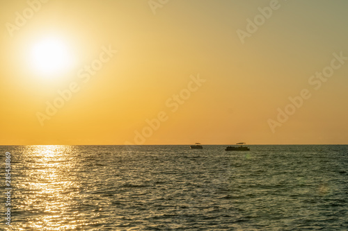 Beautiful Golden sunset on the sea. In the sea at sunset sail boats. © yaroslav1986