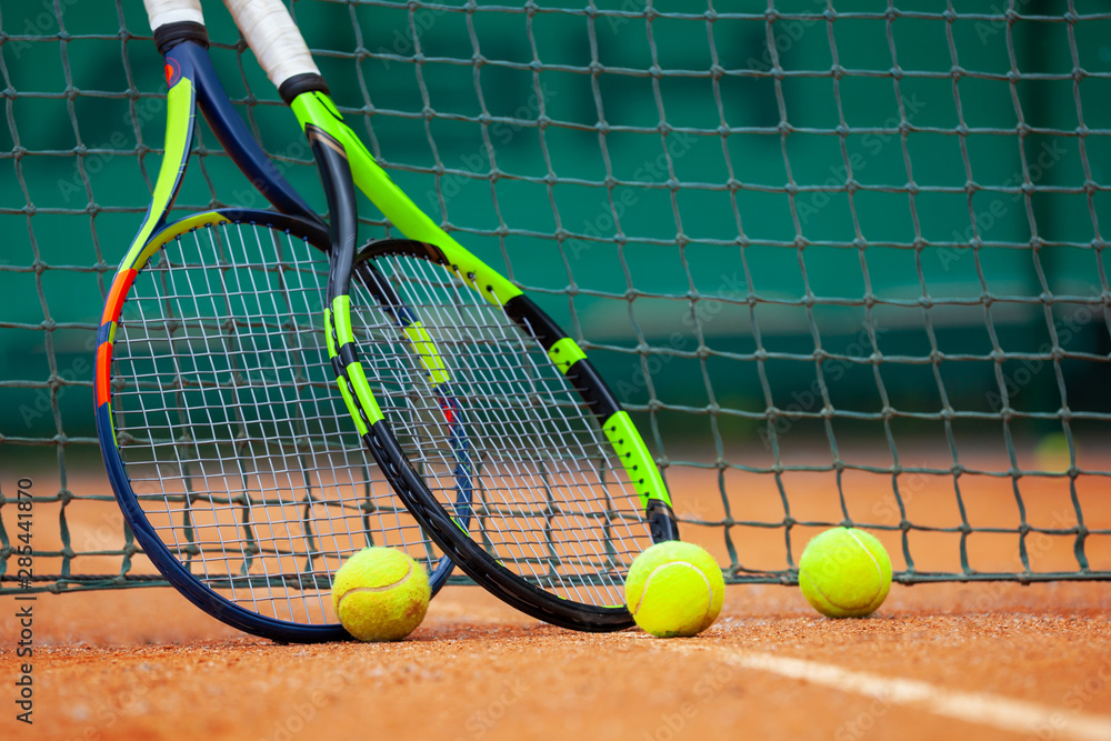 Tennis rackets and balls leaned against the net.