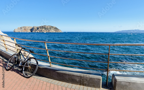 Bicicleta aparcada en l 'Estartit con las Islas Medes al fondo, Costa Brava , España photo