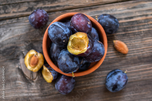 Fresh organic plums on old wooden table.